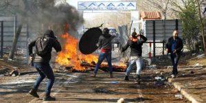 Migrants throw objects during clashes with Greek police, at the Turkey's Pazarkule border crossing with Greece's Kastanies, in Edirne - TA NEA - TA NEA
