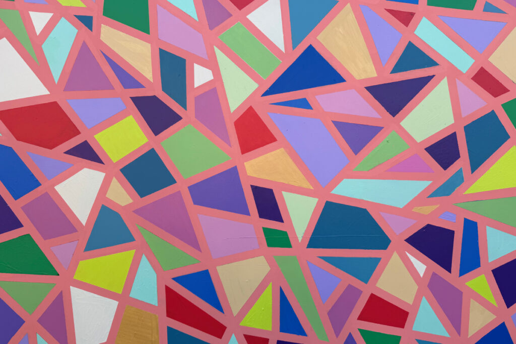 Vibrant abstract mural of irregular polygons in bright colors separated by pink lines.